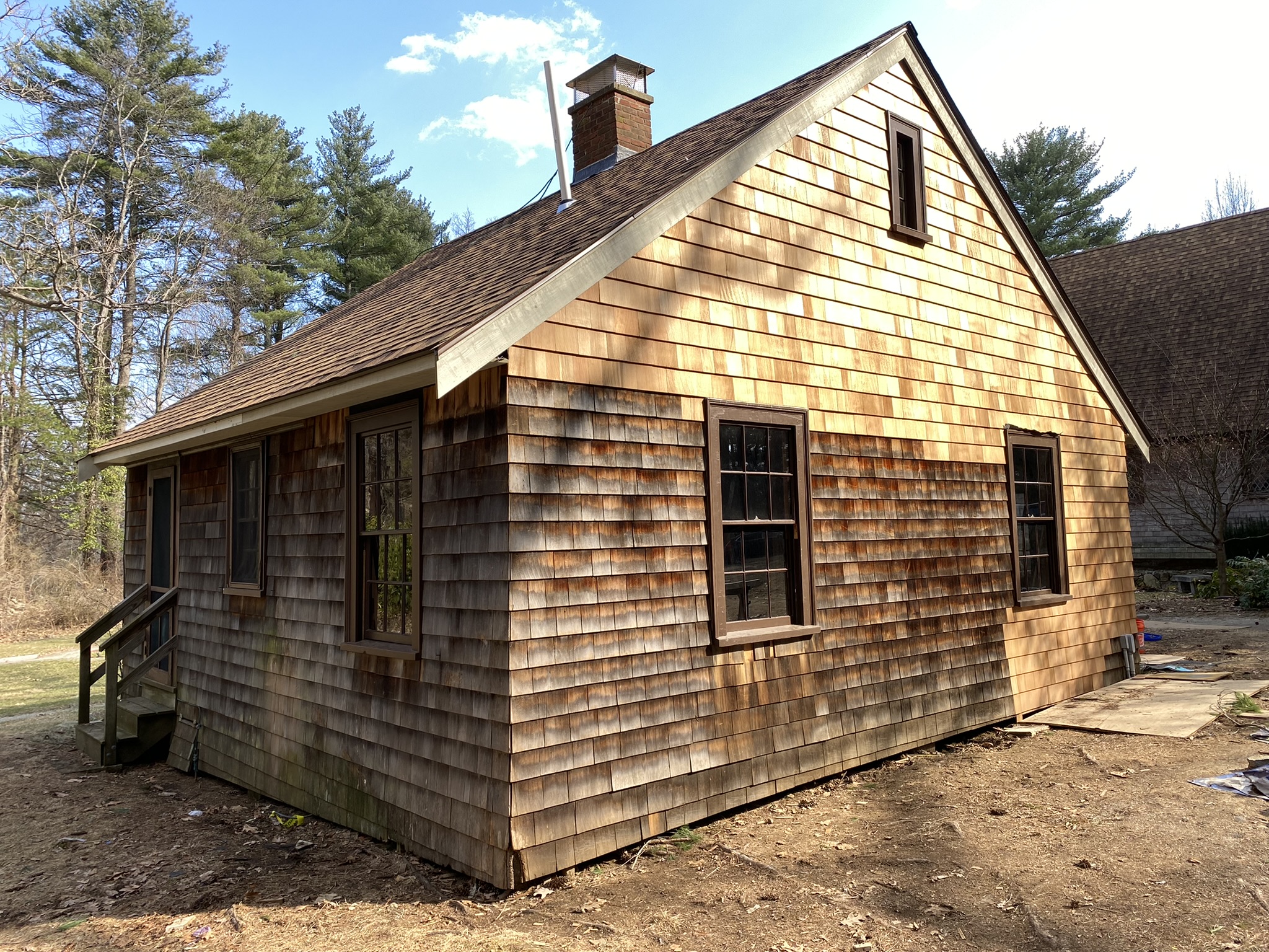 new wood shingle siding on a repaired cabin